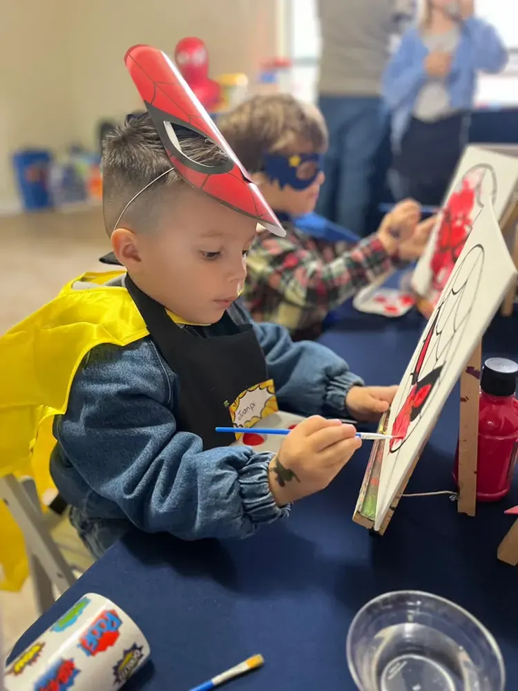 Niño pintando un cuadro en su caballete