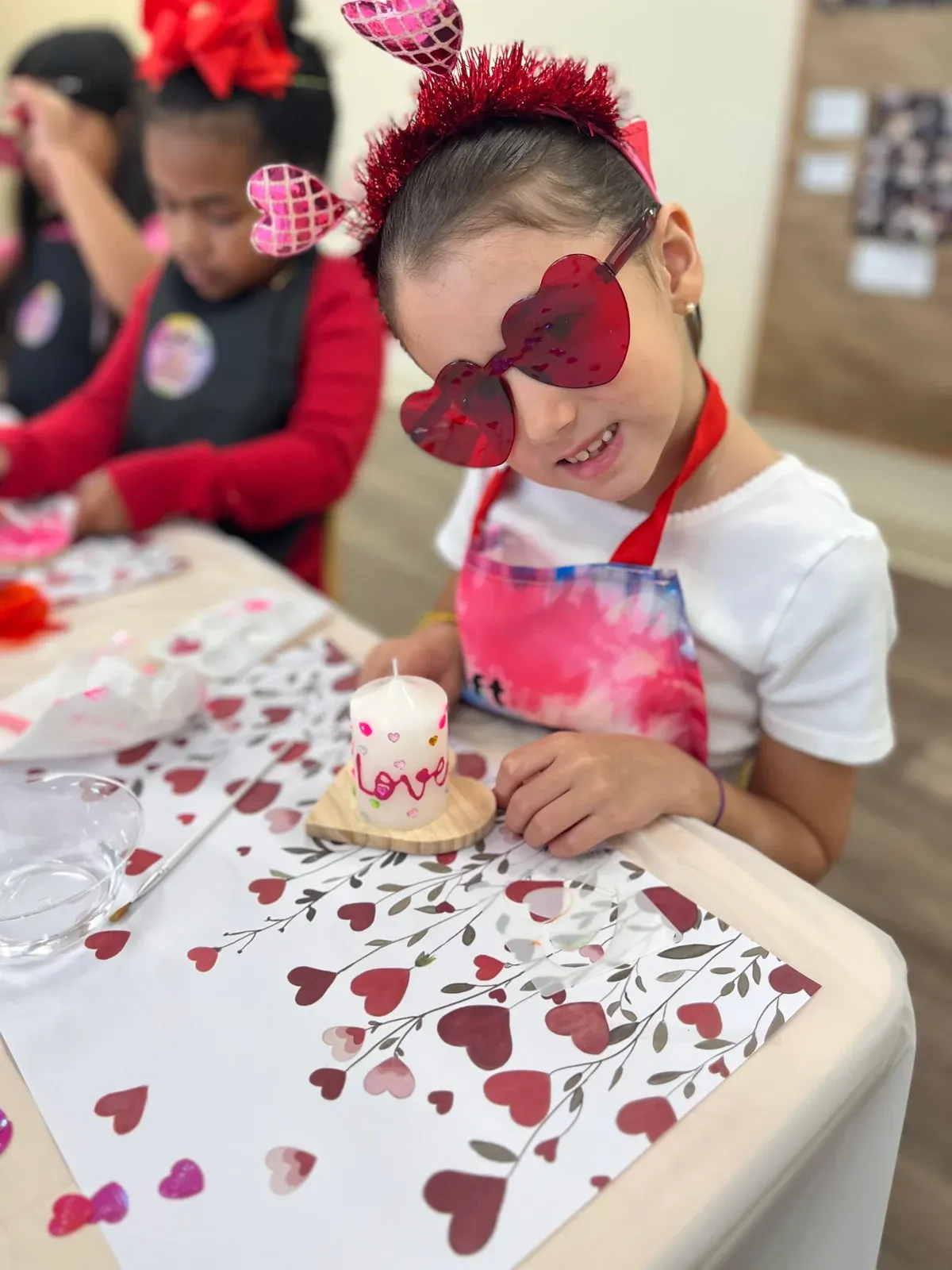Niña decorando una manualidad de corazones
